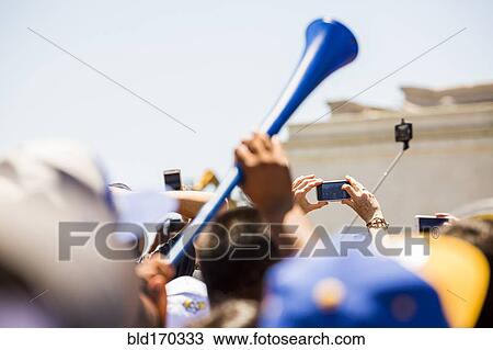 Stock Image - Crowd of fans cheering at sporting event. Fotosearch