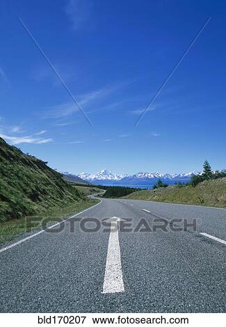 Stock Photo - Directional arrow on empty remote road. Fotosearch