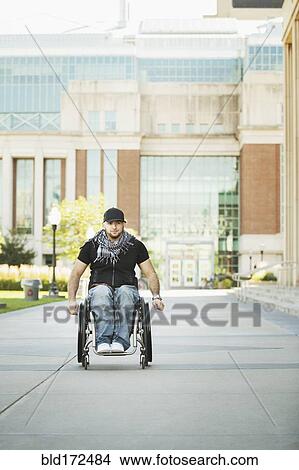 Disabled student rolling in wheelchair on college campus View Large Photo Image Picture - Disabled student rolling in wheelchair on college campus. Fotosearch