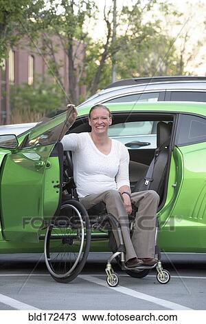 Disabled woman in wheelchair climbing into car View Large Photo Image Stock Image - Disabled woman in wheelchair climbing into car. Fotosearch