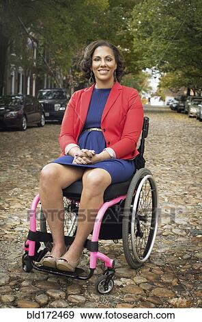 Disabled woman smiling in wheelchair on cobblestone street View Large Photo Image Stock Photo - Disabled woman smiling in wheelchair on cobblestone street. Fotosearch