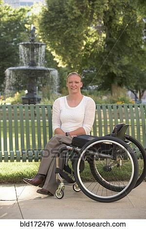 Disabled woman with wheelchair sitting on bench View Large Photo Image Stock Photograph - Disabled woman with wheelchair sitting on bench. Fotosearch