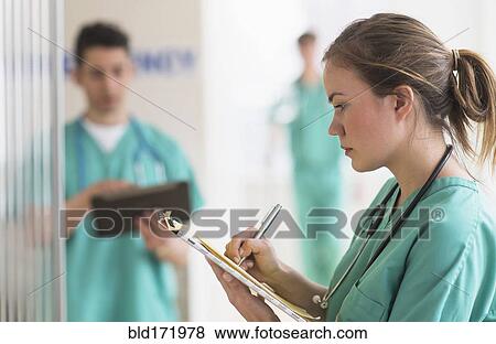 Doctor writing notes in hospital emergency room View Large Photo Image Stock Photo - Doctor writing notes in hospital emergency room. Fotosearch