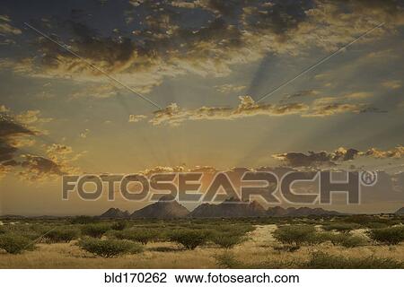 Stock Image - Dramatic sunrise over mountains in remote landscape. Fotosearch