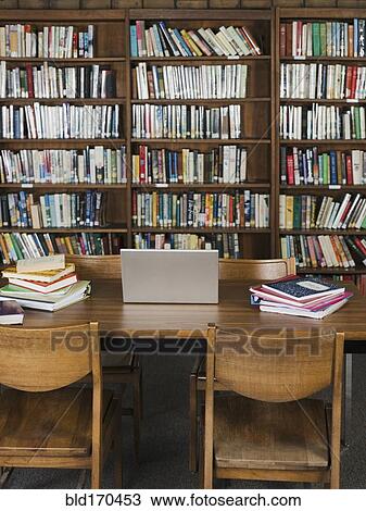 Stock Image - Empty chairs and table in library. Fotosearch
