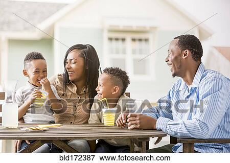 Family drinking juice in backyard View Large Photo Image Stock Photo - Family drinking juice in backyard. Fotosearch