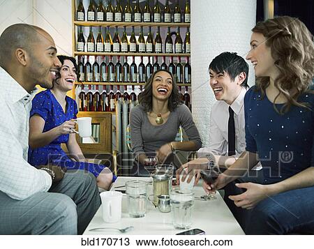 Stock Image - Friends celebrating birthday in restaurant. Fotosearch