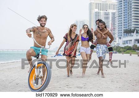Stock Photo - Friends walking on urban beach. Fotosearch