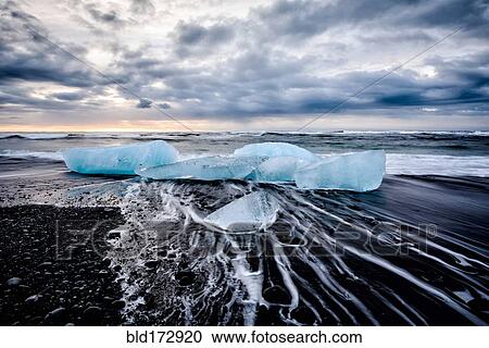 Stock Image - Glaciers washing up on remote beach. Fotosearch