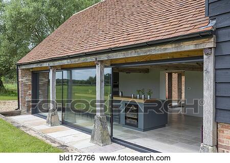 Stock Photograph - Glass sliding doors of converted barn home. Fotosearch