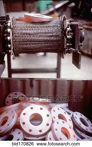 Stock Photograph - Glowing metal manufactured pieces on conveyor belt. Fotosearch