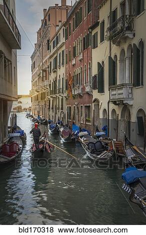Stock Photo - Gondoliers sailing on Venice canal, Veneto, Italy. Fotosearch