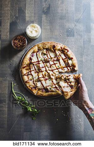 Picture - Hand choosing slice of pizza. Fotosearch