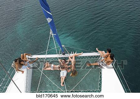 High angle view of friends sunbathing on sailboat View Large Photo Image Stock Photography - High angle view of friends sunbathing on sailboat. Fotosearch