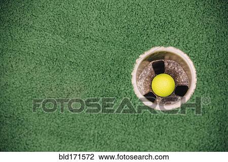 Stock Image - High angle view of golf ball in hole. Fotosearch