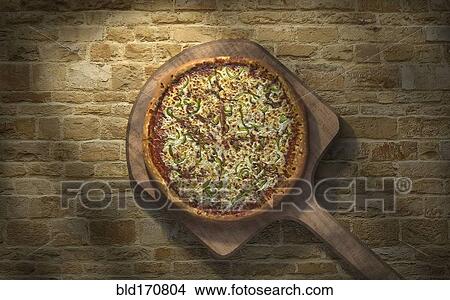Picture - High angle view of pizza on peel. Fotosearch