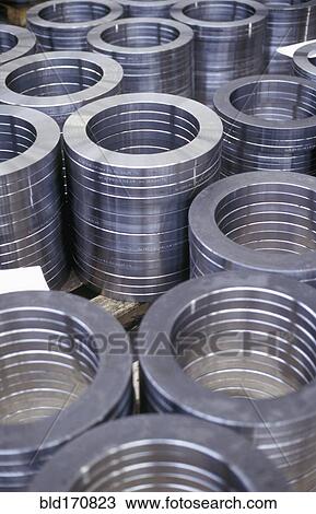 Stock Image - High angle view of stacked metal coils in factory. Fotosearch
