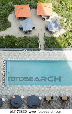 Stock Image - High angle view of tables at hotel swimming pool. Fotosearch