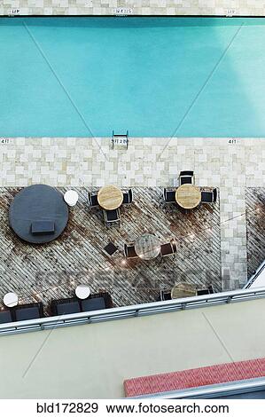 Stock Photo - High angle view of tables at hotel swimming pool. Fotosearch