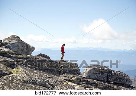 Hiker standing on hilltop in remote landscape View Large Photo Image Stock Photo - Hiker standing on hilltop in remote landscape. Fotosearch