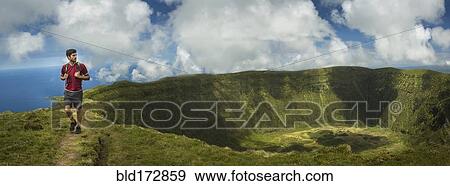 Hiker walking on hilltop dirt path over Cabeco Gordo crater, Faial, Portugal View Large Photo Image Stock Photo - Hiker walking on hilltop dirt path over Cabeco Gordo crater, Faial, Portugal. Fotosearch