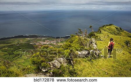 Stock Photo - Hiker walking on hilltop path in rural landscape. Fotosearch