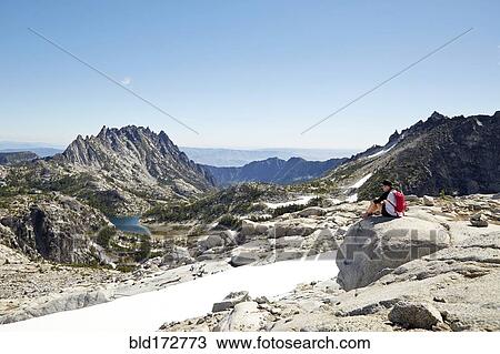Stock Image - Hikers admiring mountains in remote landscape. Fotosearch