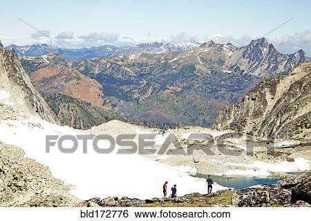 Stock Photograph - Hikers admiring mountains in remote landscape. Fotosearch
