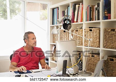 Hispanic man working in home office View Large Photo Image Stock Photo - Hispanic man working in home office. Fotosearch