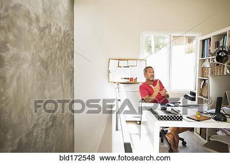 Stock Photo - Hispanic man working in home office. Fotosearch