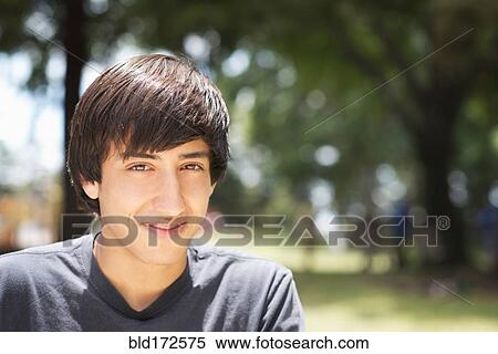 Stock Photography - Hispanic teenage boy smiling in park. Fotosearch