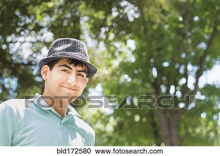 Stock Image - Hispanic teenage boy smiling outdoors. Fotosearch