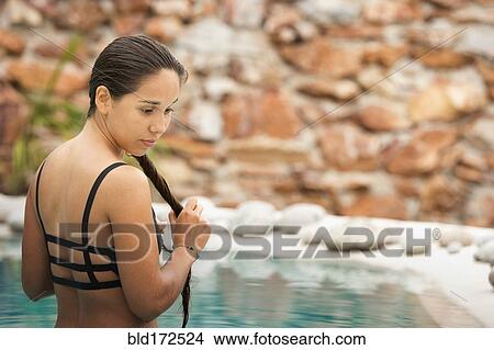 Picture - Hispanic woman swimming in pool. Fotosearch
