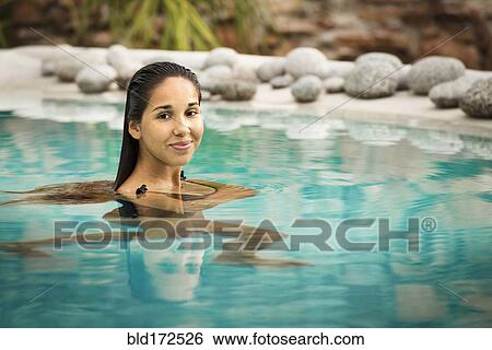 Stock Photograph - Hispanic woman swimming in pool. Fotosearch