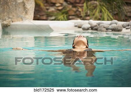 Stock Photography - Hispanic woman swimming in pool. Fotosearch
