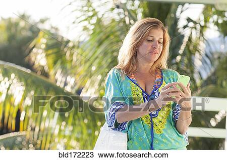 Hispanic woman using cell phone on patio View Large Photo Image Stock Image - Hispanic woman using cell phone on patio. Fotosearch