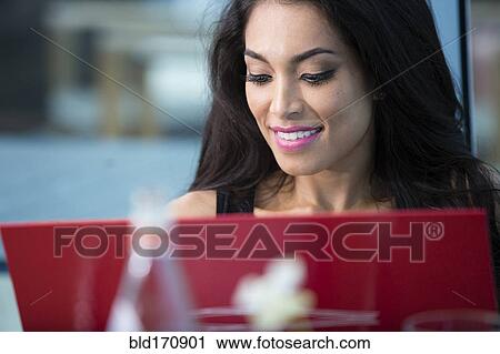 Hispanic woman using laptop in cafe View Large Photo Image Stock Image - Hispanic woman using laptop in cafe. Fotosearch