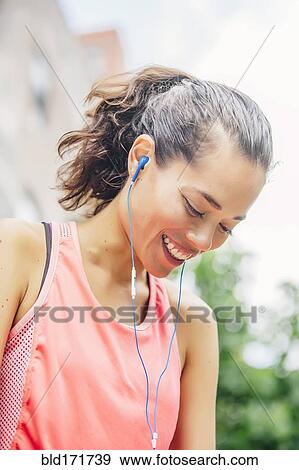 Stock Photo - Indian athlete listening to earbuds. Fotosearch