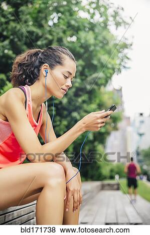 Stock Photo - Indian athlete listening to mp3 player in city. Fotosearch