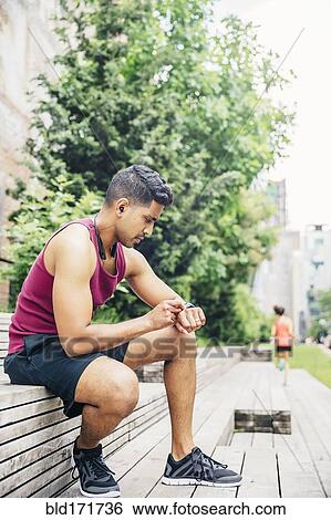 Stock Photograph - Indian athlete timing himself in city. Fotosearch
