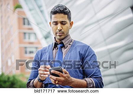 Indian businessman using cell phone outdoors View Large Photo Image Stock Photo - Indian businessman using cell phone outdoors. Fotosearch