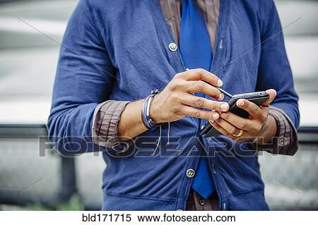 Stock Photography - Indian businessman using cell phone outdoors. Fotosearch