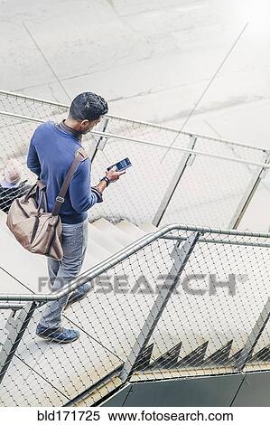 Stock Photography - Indian businesswoman using cell phone on steps. Fotosearch