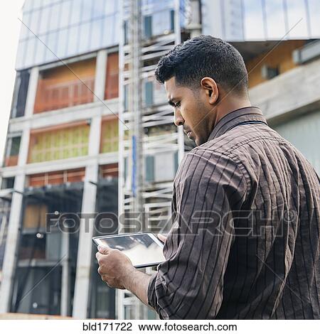 Stock Image - Indian businesswoman using digital tablet outdoors. Fotosearch