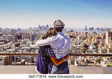 Stock Photograph - Indian couple admiring New York cityscape, New York, United States. Fotosearch