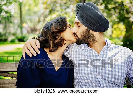 Indian couple kissing on bench in urban park View Large Photo Image Stock Photograph - Indian couple kissing on bench in urban park. Fotosearch