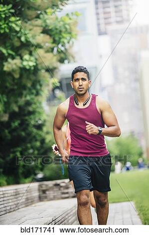 Stock Image - Indian man jogging in city. Fotosearch