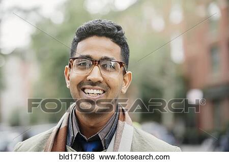 Stock Photo - Indian man smiling in city. Fotosearch
