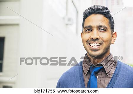 Stock Photography - Indian man smiling outdoors. Fotosearch