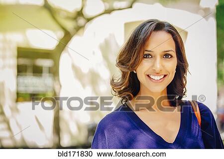 Stock Image - Indian woman smiling outdoors. Fotosearch